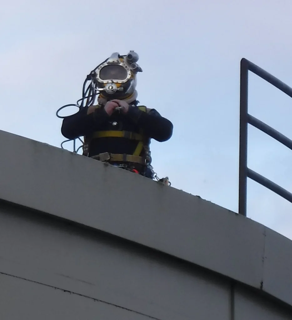 Diver suiting up to clean a city water tank